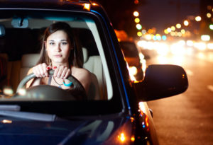 Young asian woman driving car in the night city